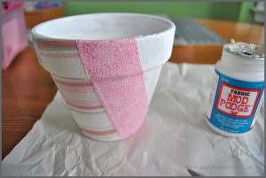 Decorate your space with a Fabric Covered Flower Pot. Visit Sparkles of Sunshine to learn how to use Mod Podge and fabric to decorate your boring flower pots!