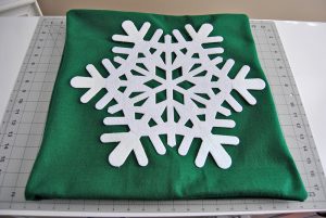 Make the easiest dollar store holiday pillow cover for just a few dollars worth of materials. It's great for decorating your home for the holidays on a budget.